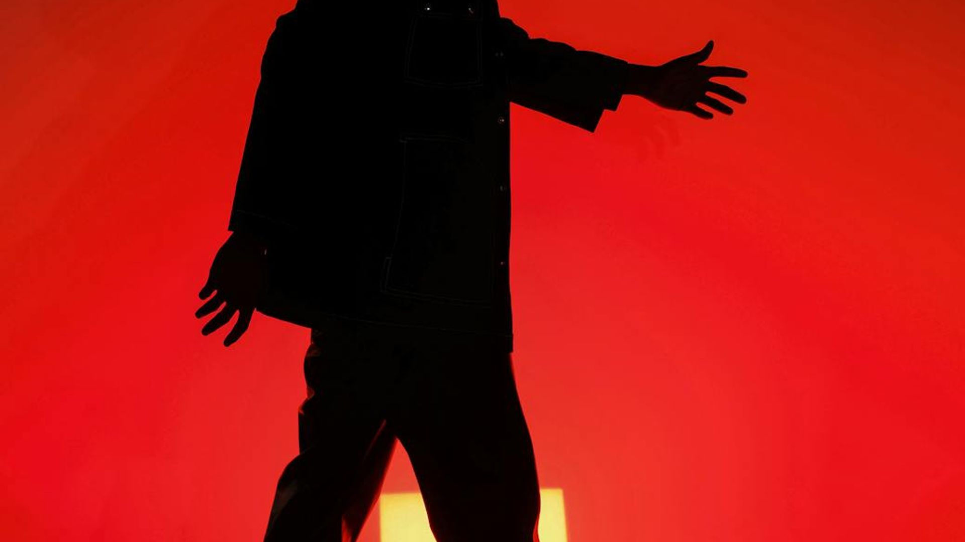 Silhouette of a person in a dynamic movement pose against a dark background.
